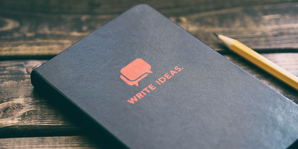 A notebook with "write ideas" embossed on it, and a pencil on the side